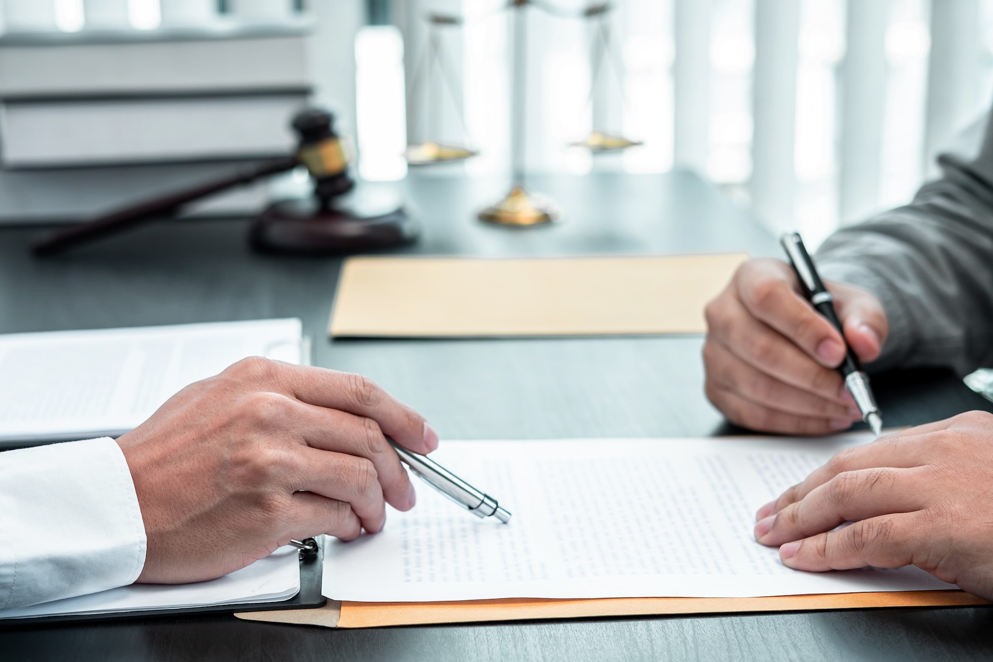 Male lawyer discussing negotiation legal case with client meeting with document contract in office